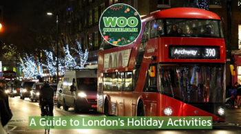 red london bus riding along a street with christmas lights at night