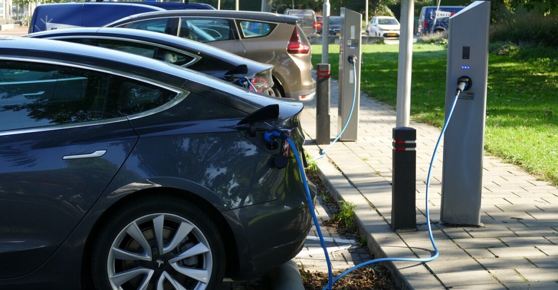 image shows a row of electric cars charging